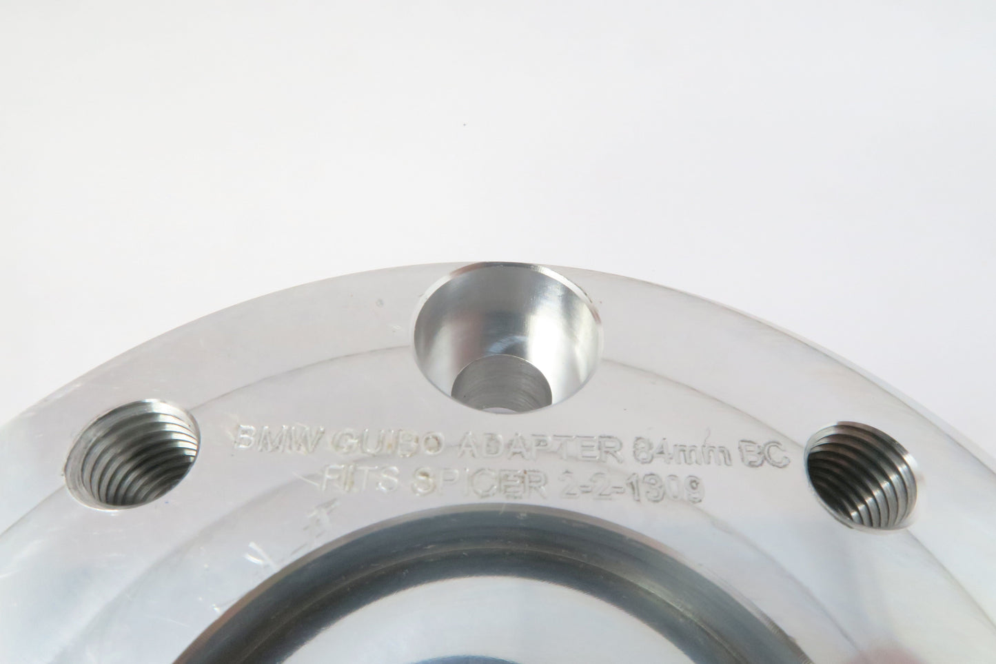 Aluminum round drive shaft adapter for BMW approximately 4 inches wide by 1 inch high