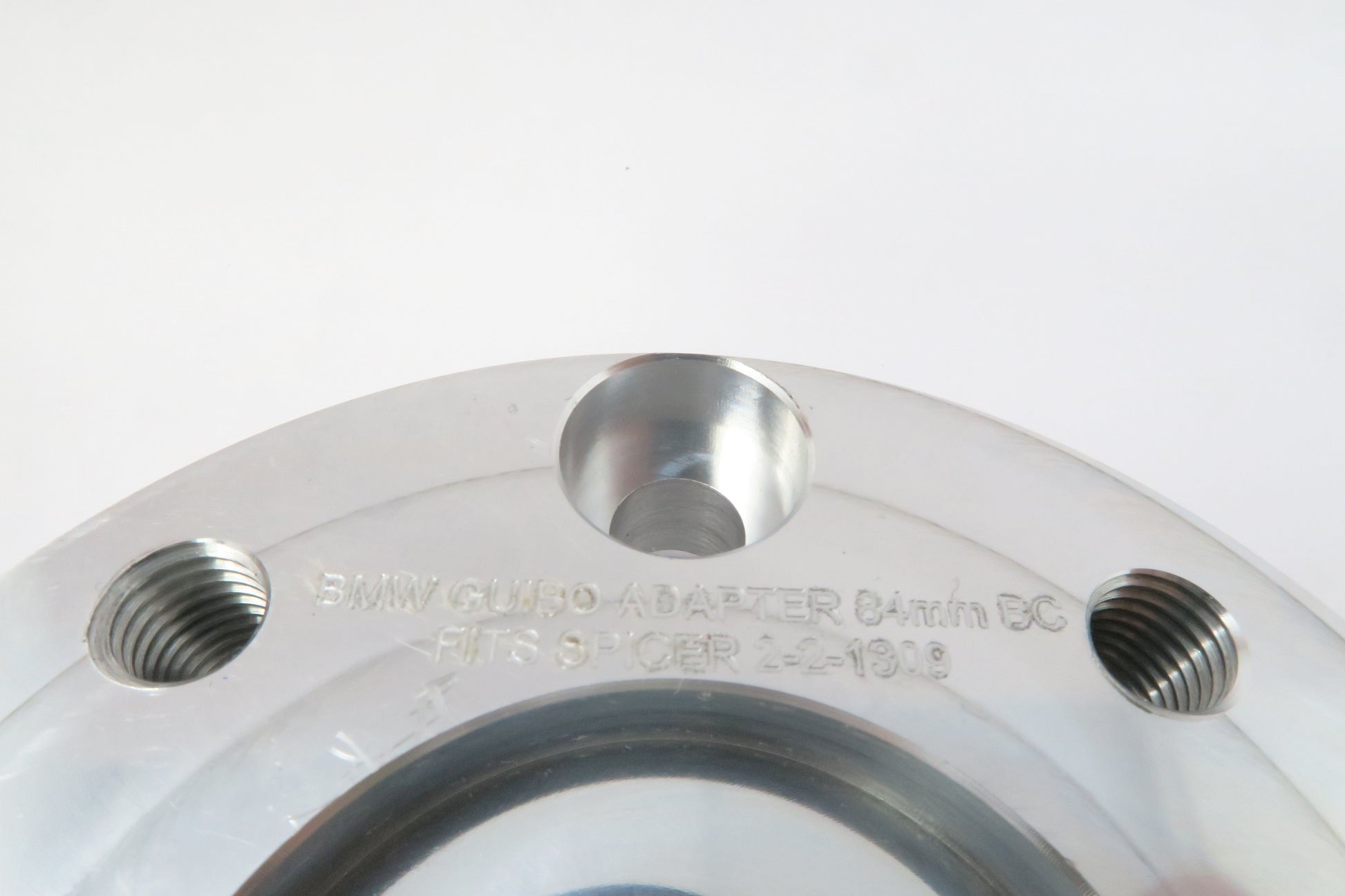 Aluminum round drive shaft adapter for BMW approximately 4 inches wide by 1 inch high